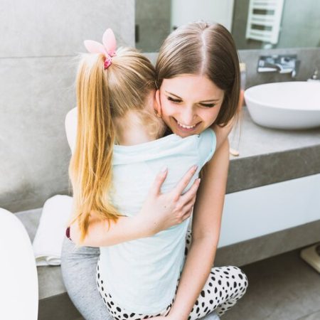 mother-embracing-daughter-bathroom_23-2147807928 روشهای درمان مثل آموزش دستشویی رفتن و زنگ ادرار